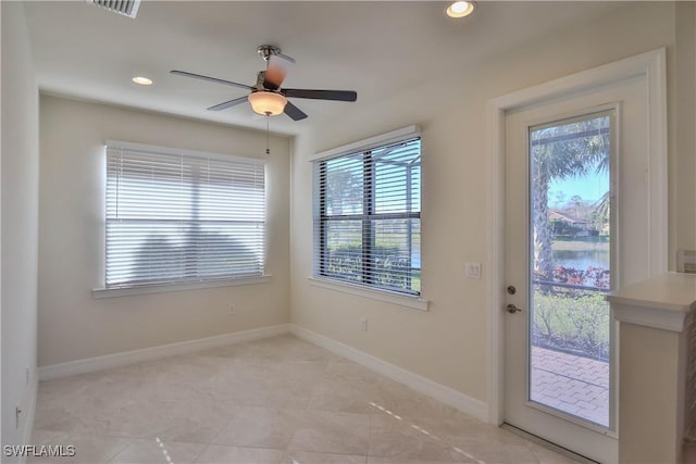 doorway with ceiling fan and a water view