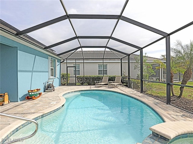 view of swimming pool with a patio and glass enclosure