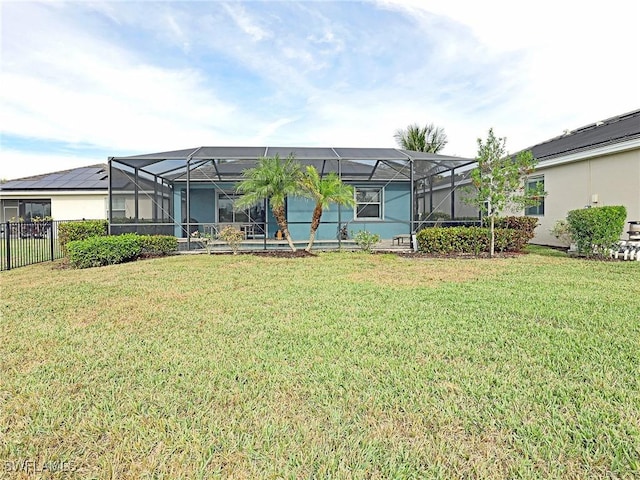 back of property with a lanai and a lawn