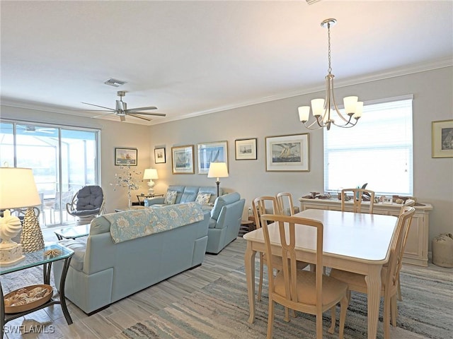 dining space with ceiling fan with notable chandelier, light hardwood / wood-style floors, and ornamental molding