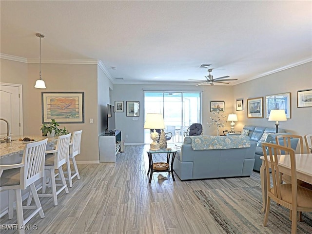 living room with ceiling fan, light hardwood / wood-style floors, and ornamental molding