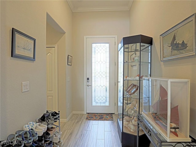 entrance foyer with light hardwood / wood-style floors and crown molding