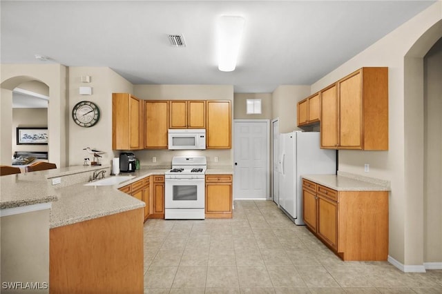 kitchen featuring kitchen peninsula, light stone counters, white appliances, sink, and light tile patterned floors