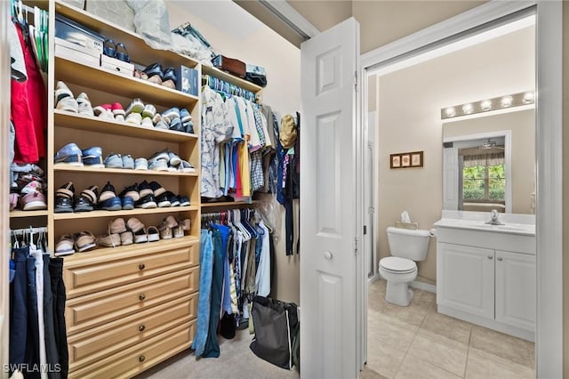 spacious closet featuring light tile patterned floors and sink