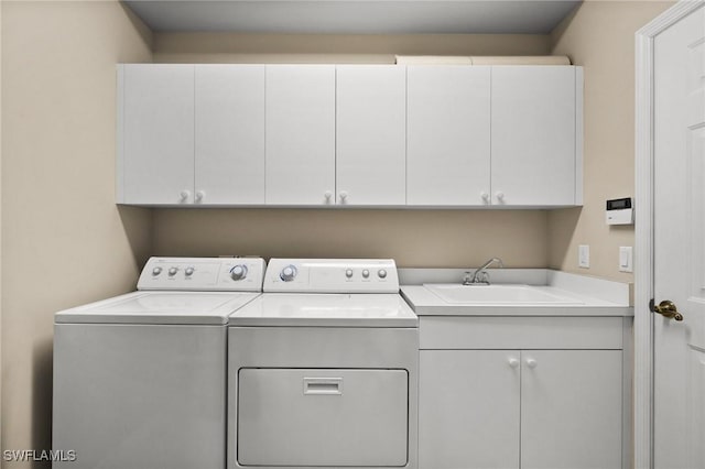 clothes washing area with cabinets, washer and clothes dryer, and sink