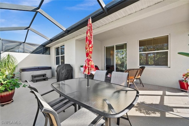 view of patio / terrace featuring glass enclosure, area for grilling, and a hot tub