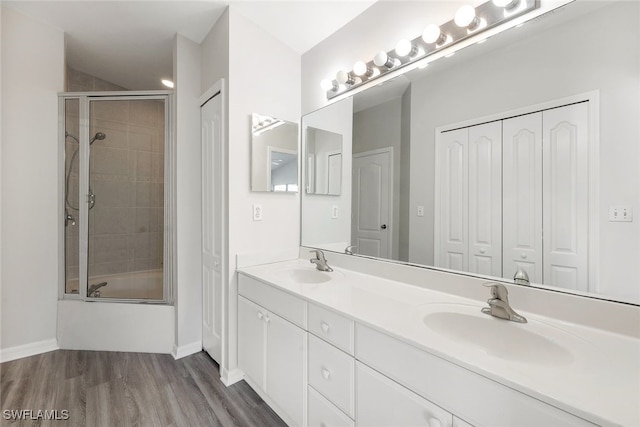 bathroom with vanity, wood-type flooring, and shower / bath combination with glass door