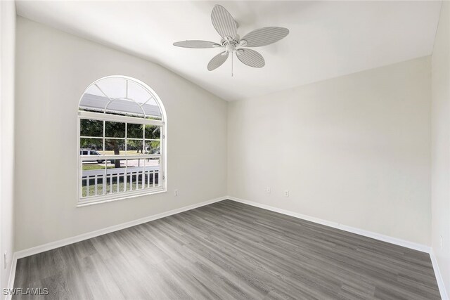 unfurnished room with ceiling fan, vaulted ceiling, and dark hardwood / wood-style flooring