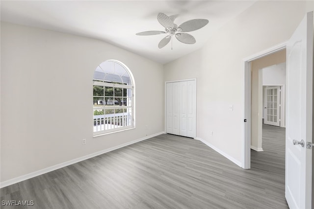 unfurnished room with vaulted ceiling, ceiling fan, and light wood-type flooring