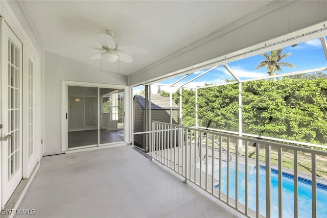 unfurnished sunroom featuring ceiling fan