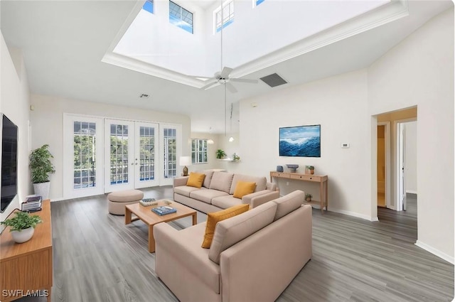 living room featuring french doors, ceiling fan, hardwood / wood-style floors, and a high ceiling