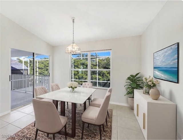 dining space with vaulted ceiling, an inviting chandelier, and light tile patterned floors