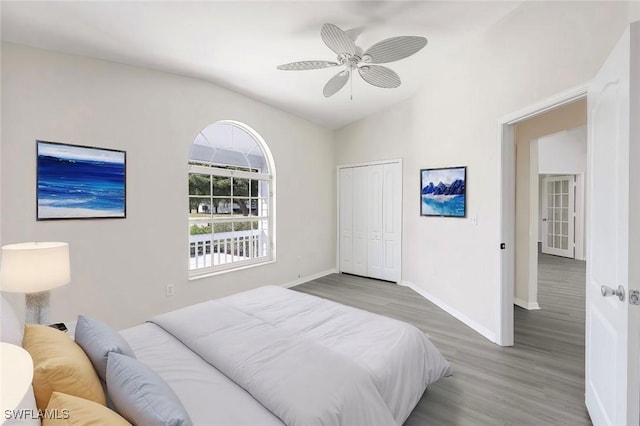 bedroom featuring ceiling fan, hardwood / wood-style flooring, a closet, and vaulted ceiling