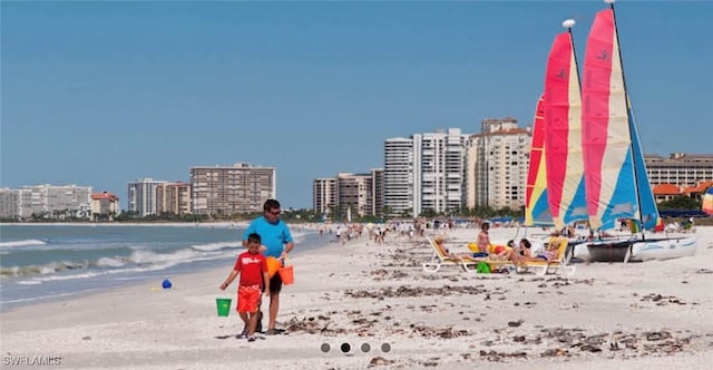 surrounding community featuring a water view and a view of the beach