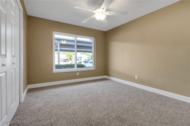 carpeted spare room featuring ceiling fan