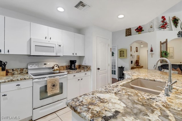 kitchen featuring white appliances, white cabinetry, light stone counters, and sink