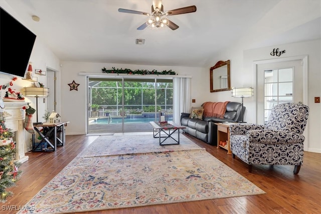 living room with ceiling fan, vaulted ceiling, and hardwood / wood-style flooring