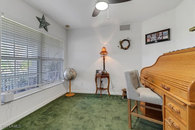 sitting room with ceiling fan and dark carpet