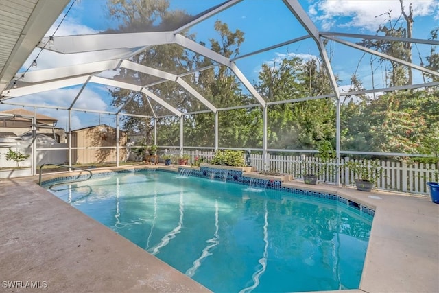 view of swimming pool with pool water feature, glass enclosure, and a patio area