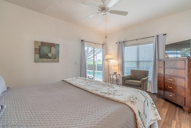 bedroom with access to exterior, hardwood / wood-style flooring, and ceiling fan