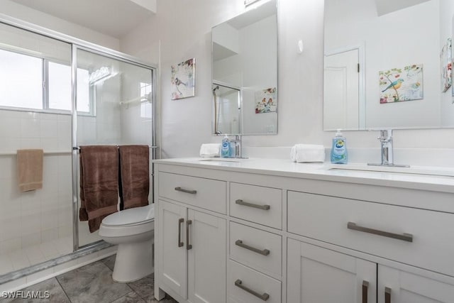 bathroom with tile patterned flooring, a shower with door, vanity, and toilet