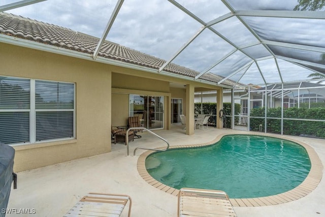 view of swimming pool featuring a patio and glass enclosure