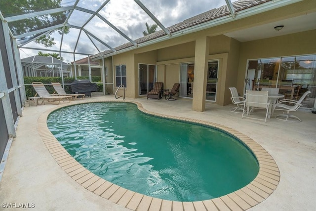 view of swimming pool with a patio area, area for grilling, and glass enclosure