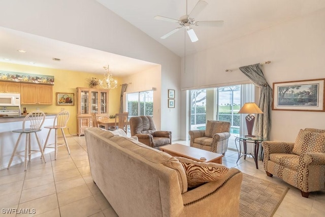 tiled living room featuring high vaulted ceiling, ceiling fan with notable chandelier, and a wealth of natural light