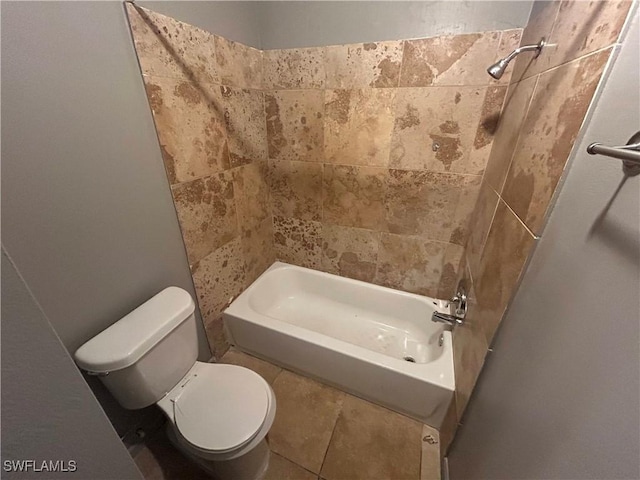 bathroom with toilet and tiled shower / bath