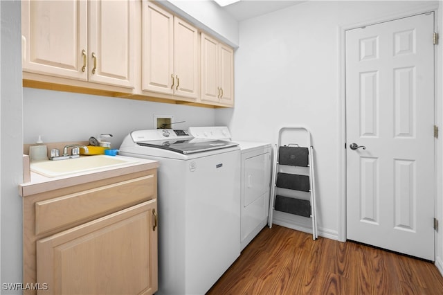 washroom featuring dark hardwood / wood-style flooring, cabinets, sink, and washing machine and clothes dryer