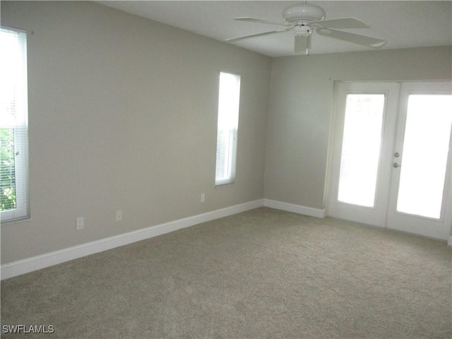 unfurnished room featuring light carpet, french doors, and ceiling fan