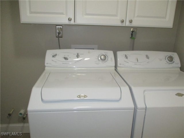 washroom featuring cabinets and independent washer and dryer