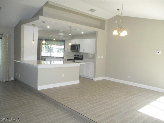 kitchen with white cabinets, pendant lighting, appliances with stainless steel finishes, and vaulted ceiling