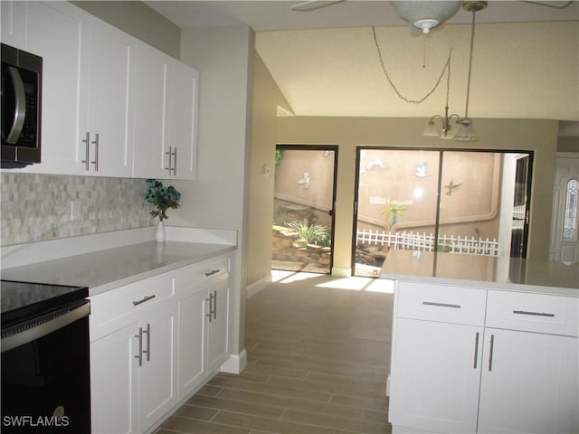 kitchen with pendant lighting, backsplash, an inviting chandelier, white cabinets, and light hardwood / wood-style floors