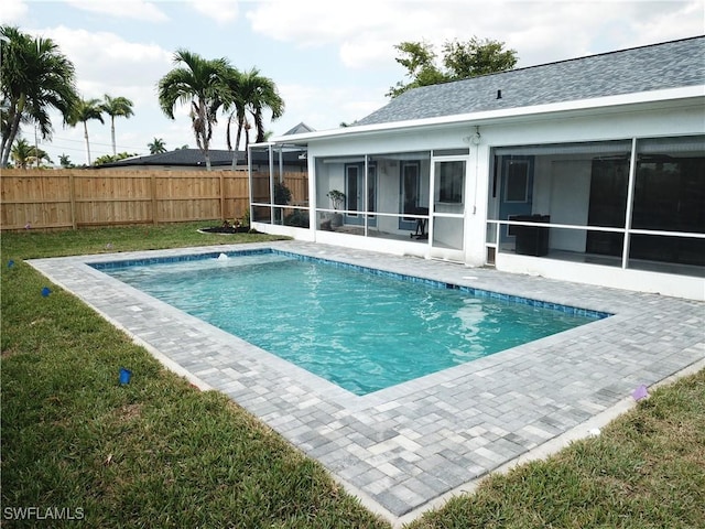 view of pool featuring a lawn and a sunroom