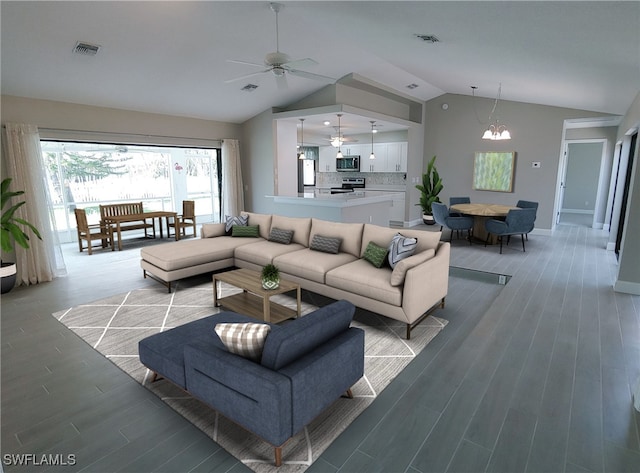 living room with ceiling fan with notable chandelier, hardwood / wood-style flooring, and lofted ceiling