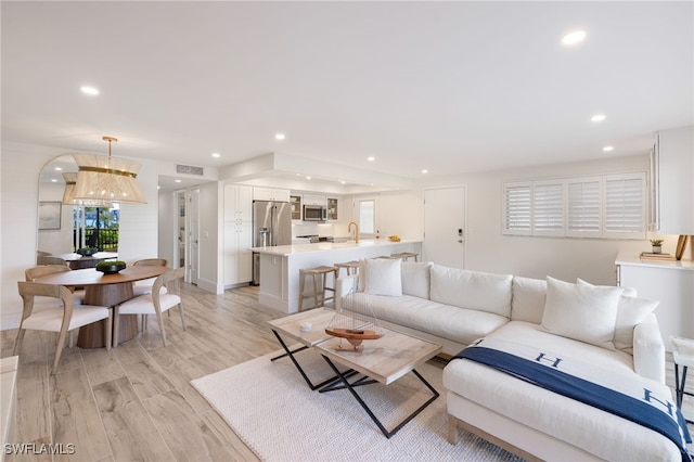 living room with light wood-type flooring and sink