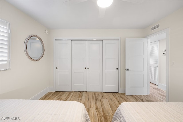 bedroom with ceiling fan, a closet, and light hardwood / wood-style floors