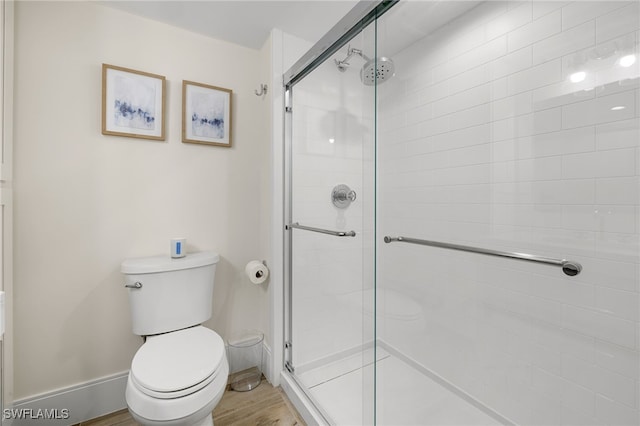 bathroom with toilet and a shower with door