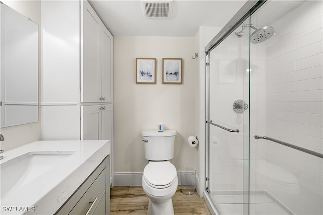 bathroom with vanity, toilet, wood-type flooring, and walk in shower