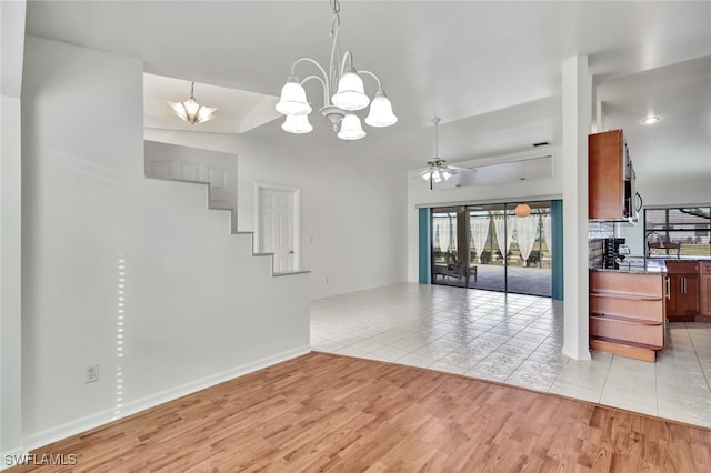 interior space featuring ceiling fan with notable chandelier, plenty of natural light, and light wood-type flooring