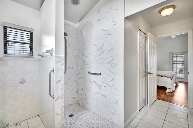 bathroom with tile patterned flooring and tiled shower