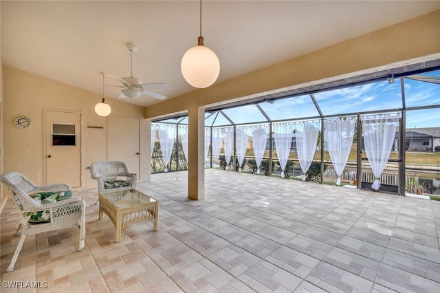 view of patio featuring ceiling fan and glass enclosure