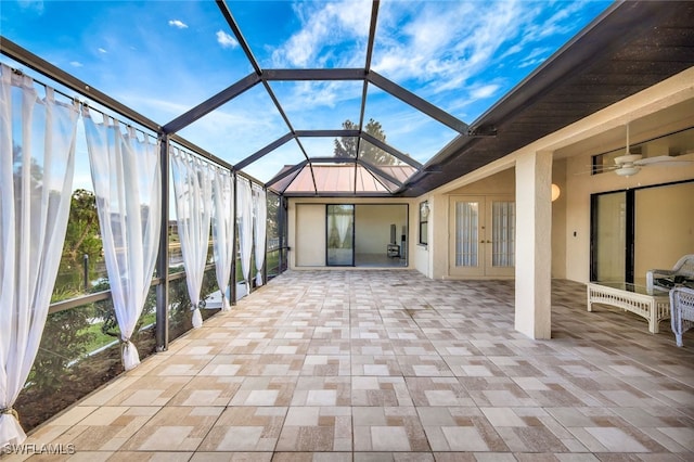 unfurnished sunroom with french doors, ceiling fan, and a patio