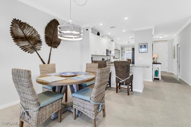 dining space featuring ornamental molding, an inviting chandelier, and sink