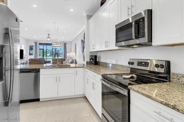 kitchen featuring white cabinets, stainless steel appliances, light stone counters, and sink