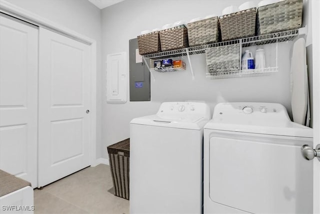 washroom with washer and dryer, electric panel, and light tile patterned floors