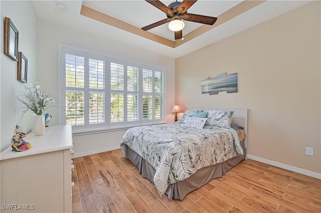 bedroom featuring a raised ceiling and ceiling fan