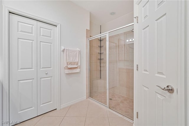 bathroom with tile patterned flooring and a shower with shower door