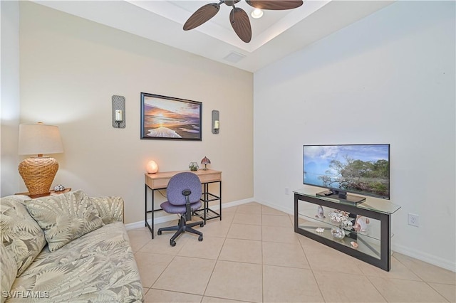 office area with a raised ceiling, ceiling fan, and light tile patterned floors